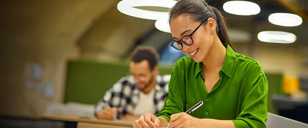 graduate student writing in notebook