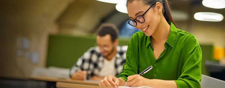 graduate student writing in notebook